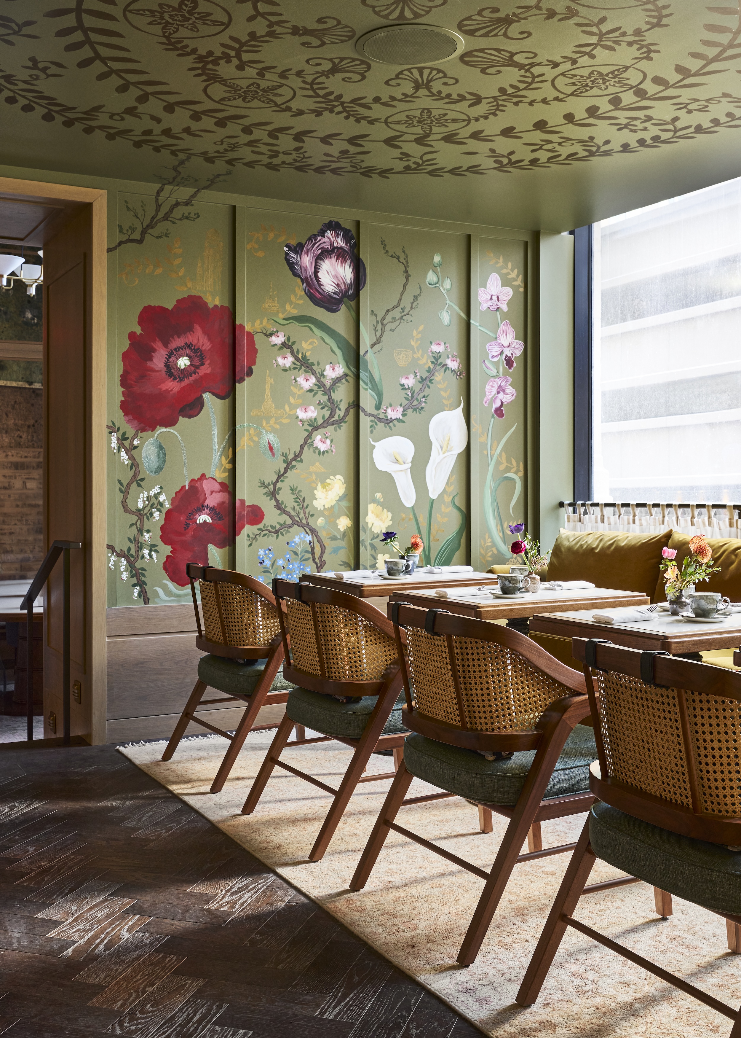 a dining area with a floral mural and a window