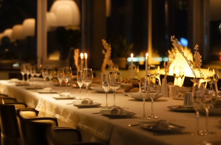 A beautifully arranged dining table is set with glasses and candles, creating a warm atmosphere for guests.
