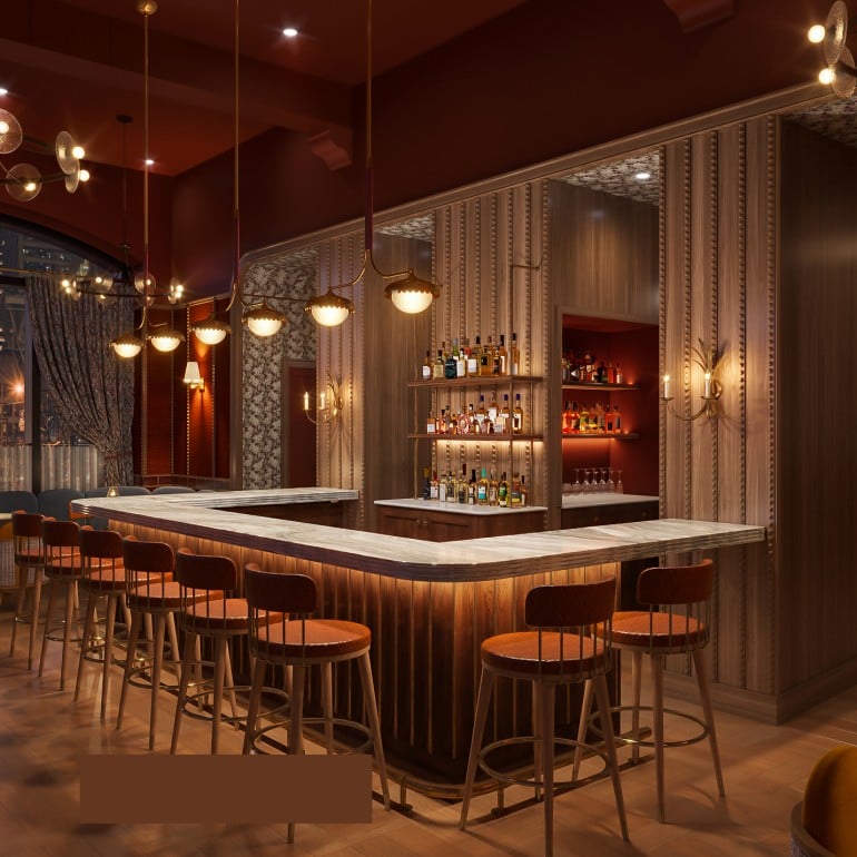 A U-shaped wooden bar with stools, illuminated from below, invites patrons in an elegant, dimly lit lounge. Large windows reveal a city night panorama.