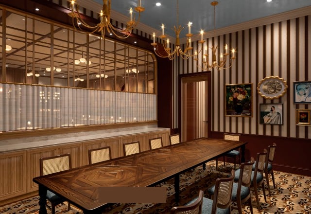 A long, ornate wooden dining table with chairs fills a luxurious room featuring striped walls, multiple artworks, golden chandeliers, and a glass-paneled partition.