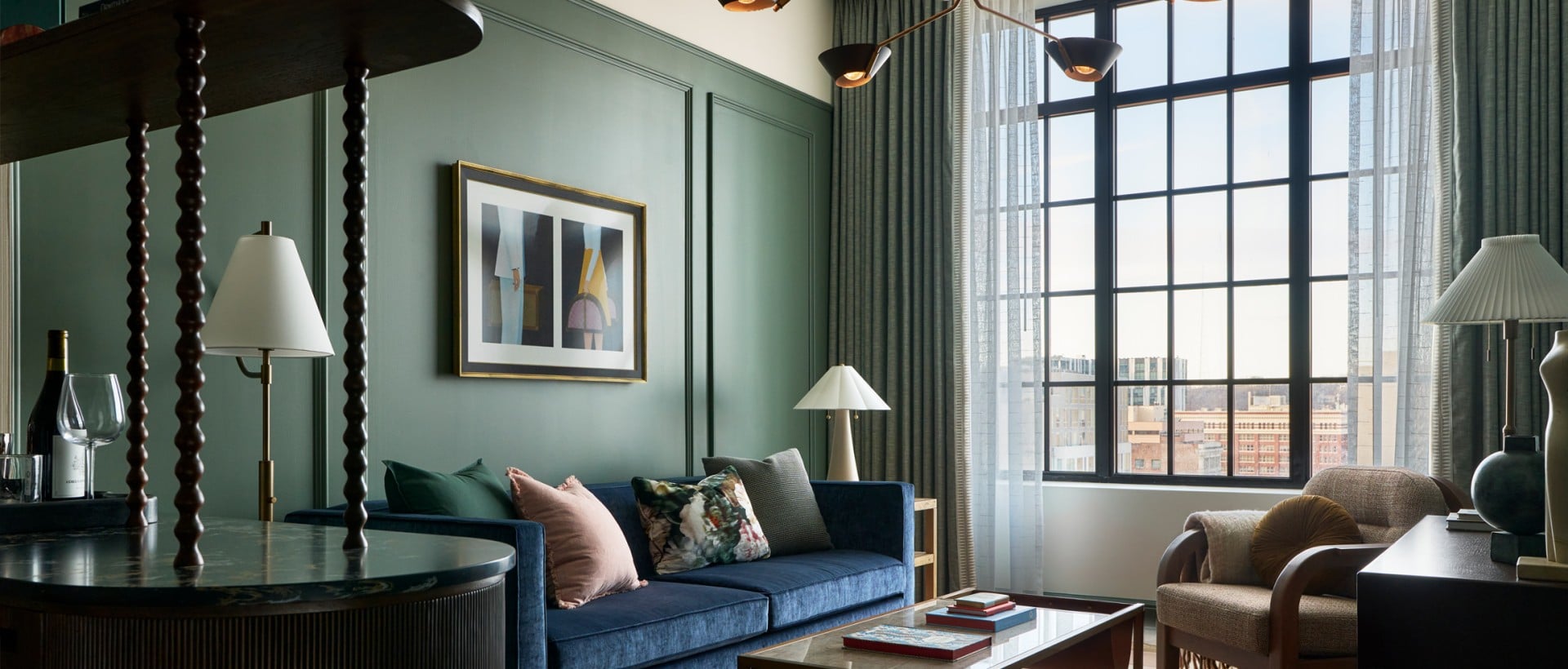 A modern living room features a blue sofa, glass coffee table, and a large grid window. Dark green paneled walls and a geometric rug define the space. Text: "Поэтическая...", "DREAM" plus illegible text.