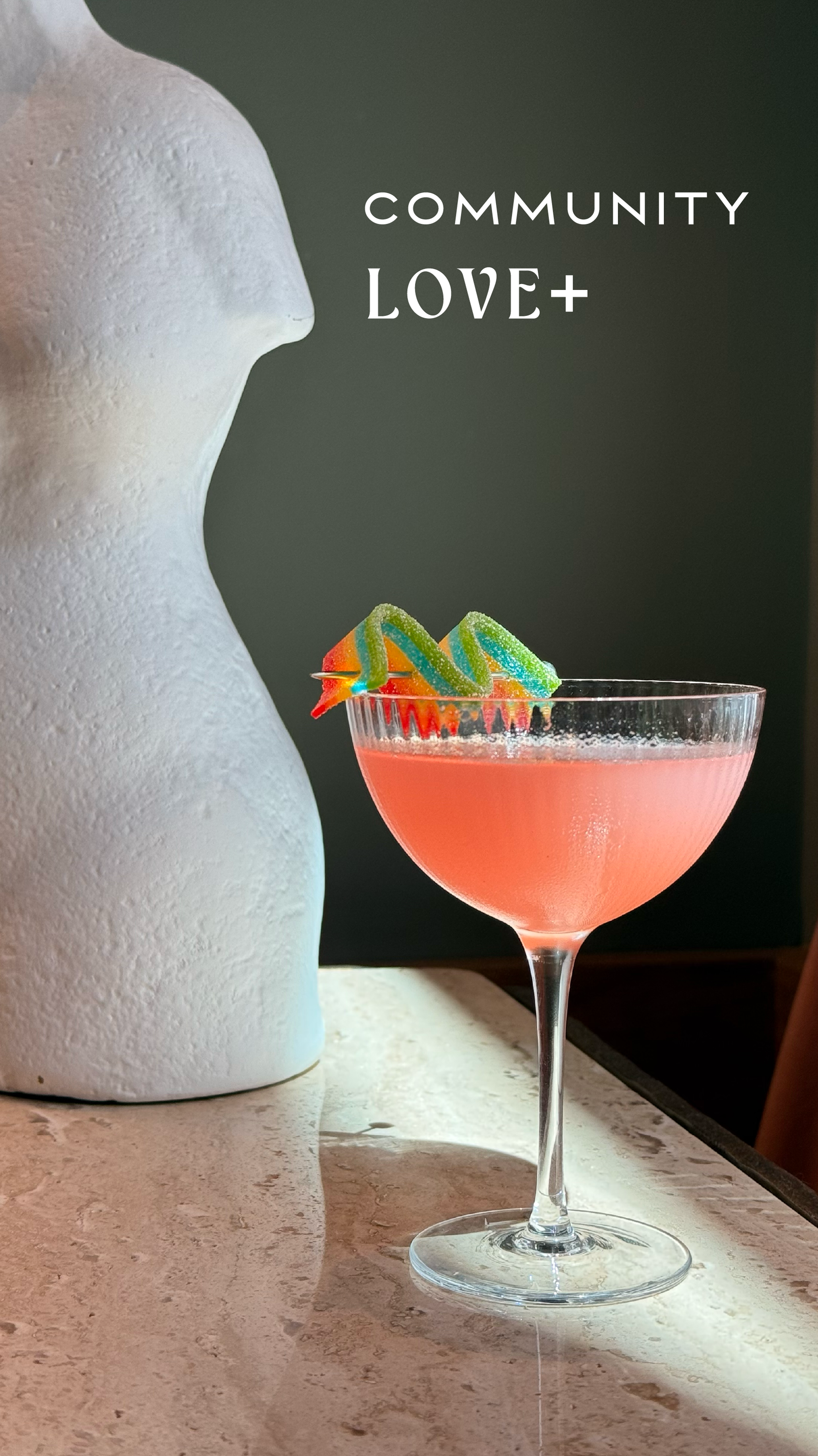 a pink cocktail with a colorful garnish