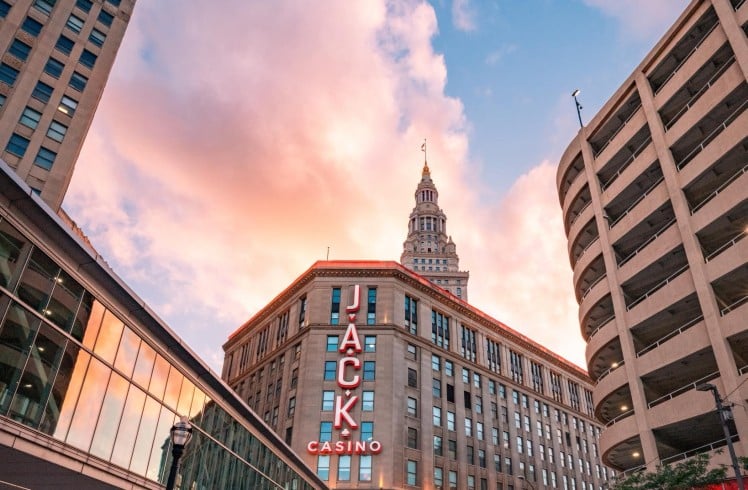 Jacks Casino skyline at sunset, with vibrant orange and purple hues illuminating the buildings and streets below.