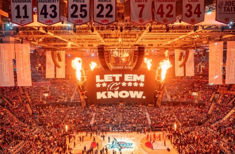 A bustling basketball arena filled with a large crowd, all focused on the game and cheering for their favorite team.