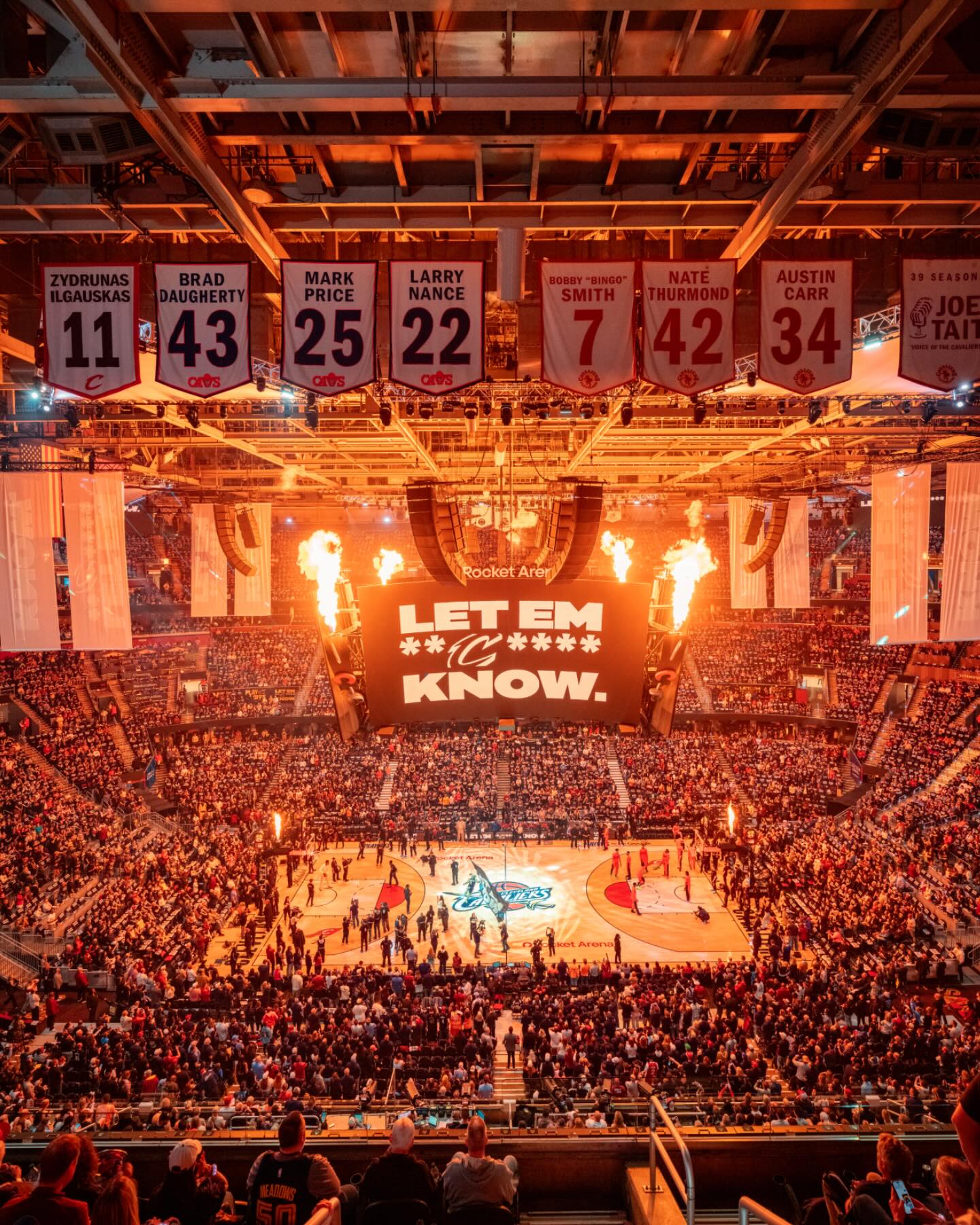 A bustling basketball arena filled with a large crowd, all focused on the game and cheering for their favorite team.