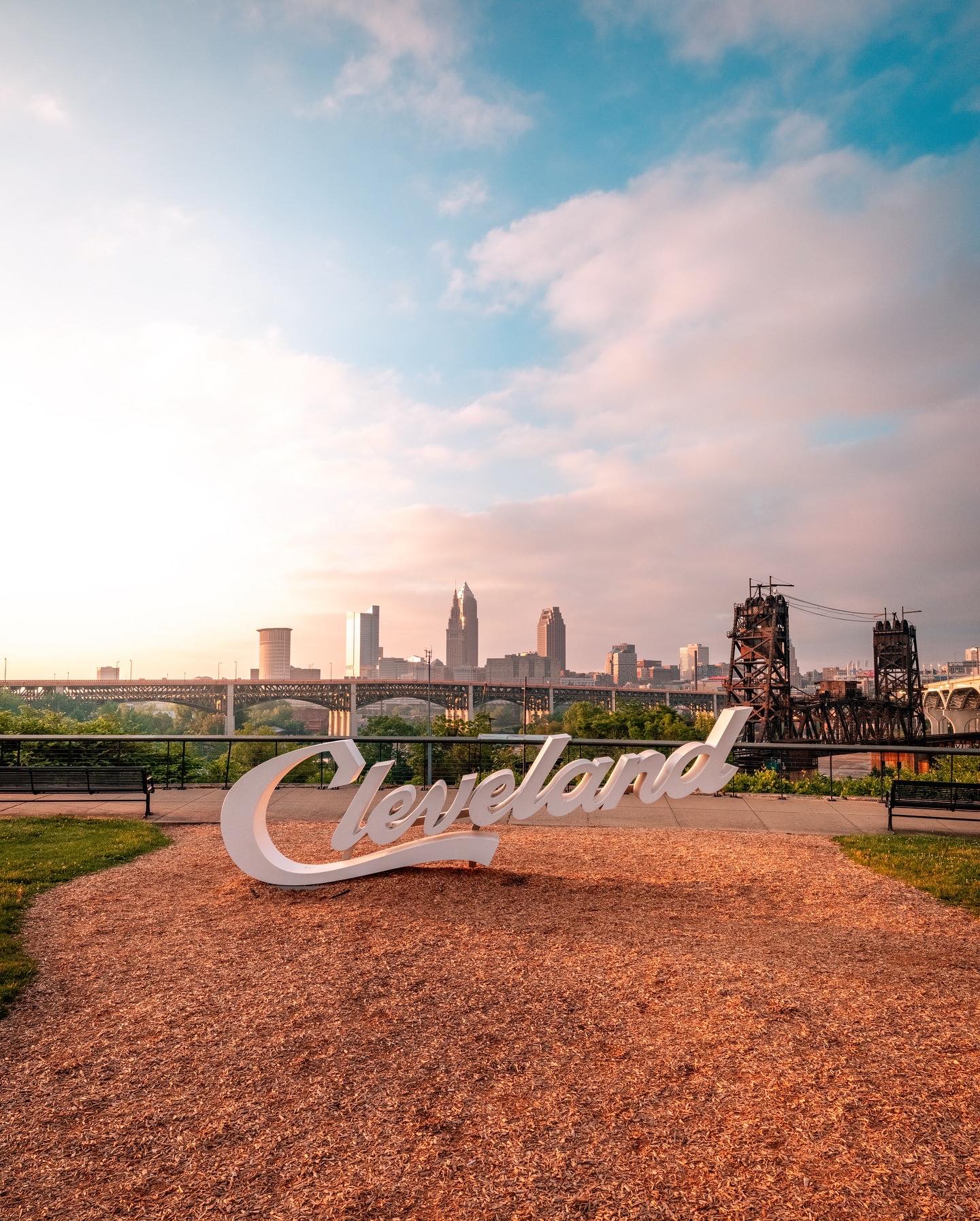 Cleveland skyline with the iconic "Cleveland" sign in the foreground, showcasing the city's urban landscape.