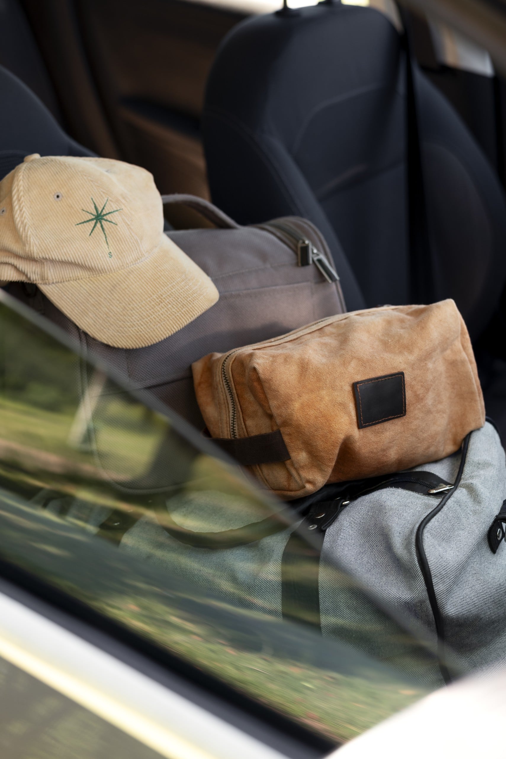 A cap and bags in the front seat of a car.