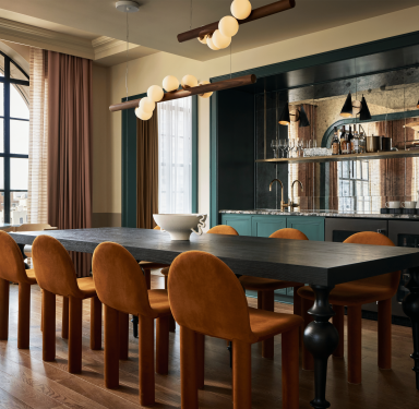 Dining room table with orange chairs in hotel suite.