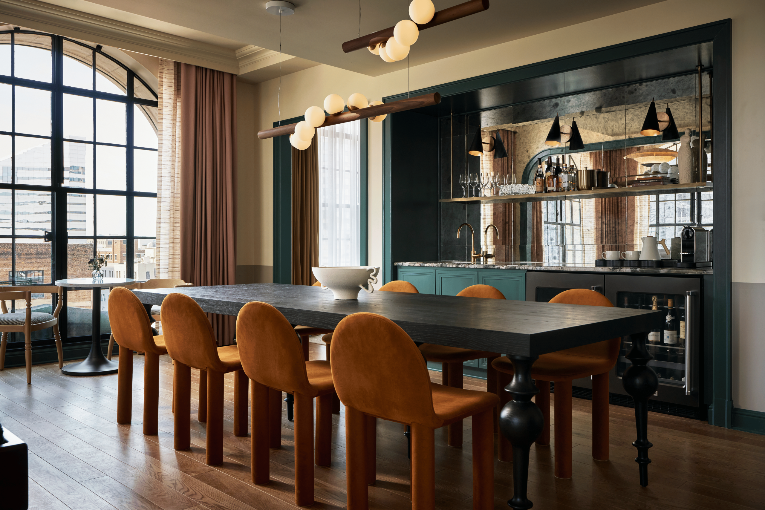 Dining room table with orange chairs in hotel suite.