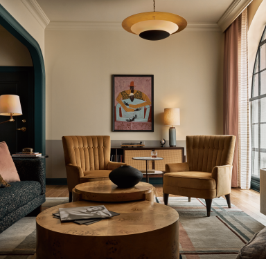 two chairs in front of art in hotel suite