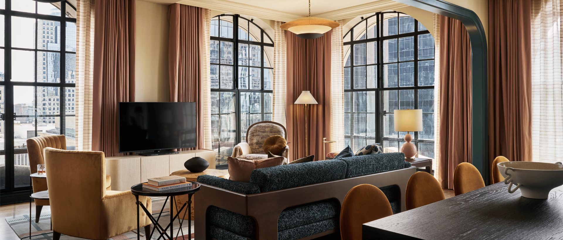 living room area in hotel suite with TV, couch, lamp and coffee table